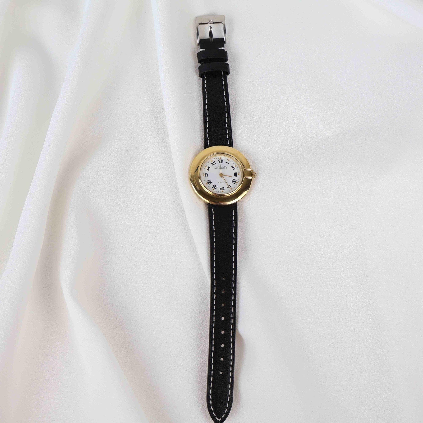 Vintage Embassy Watch with a Gold Round Face and Black Leather Strap