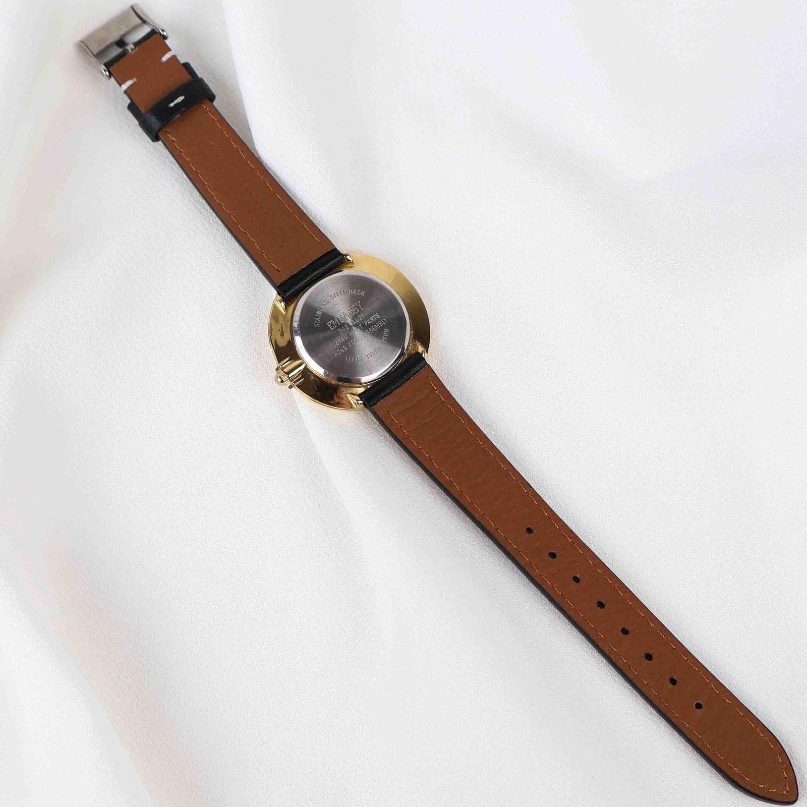 Vintage Embassy Watch with a Gold Round Face and Black Leather Strap