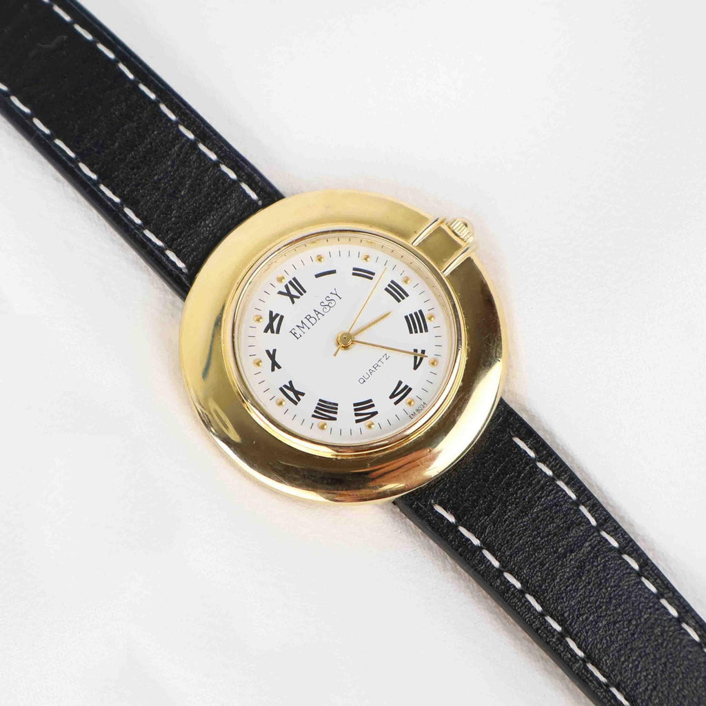 Vintage Embassy Watch with a Gold Round Face and Black Leather Strap