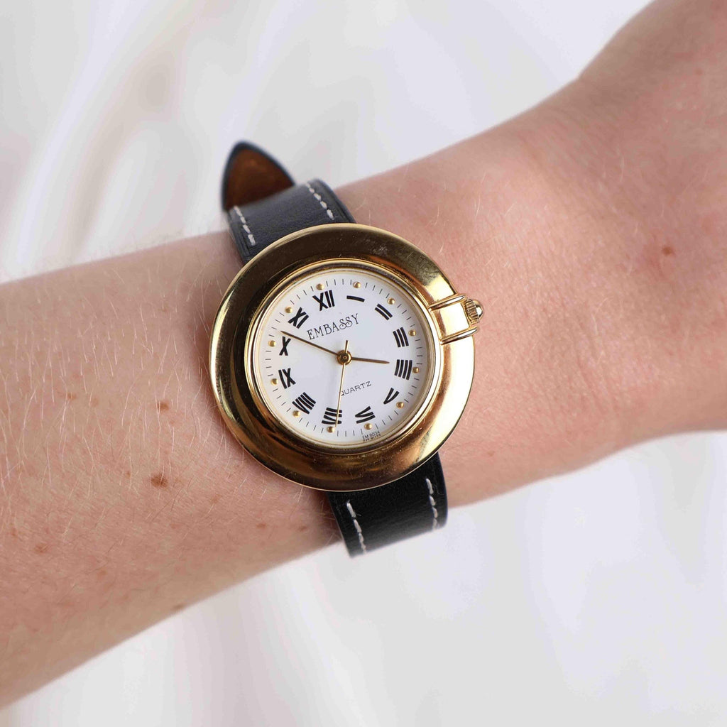 Vintage Embassy Watch with a Gold Round Face and Black Leather Strap