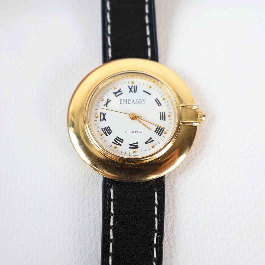 Vintage Embassy Watch with a Gold Round Face and Black Leather Strap