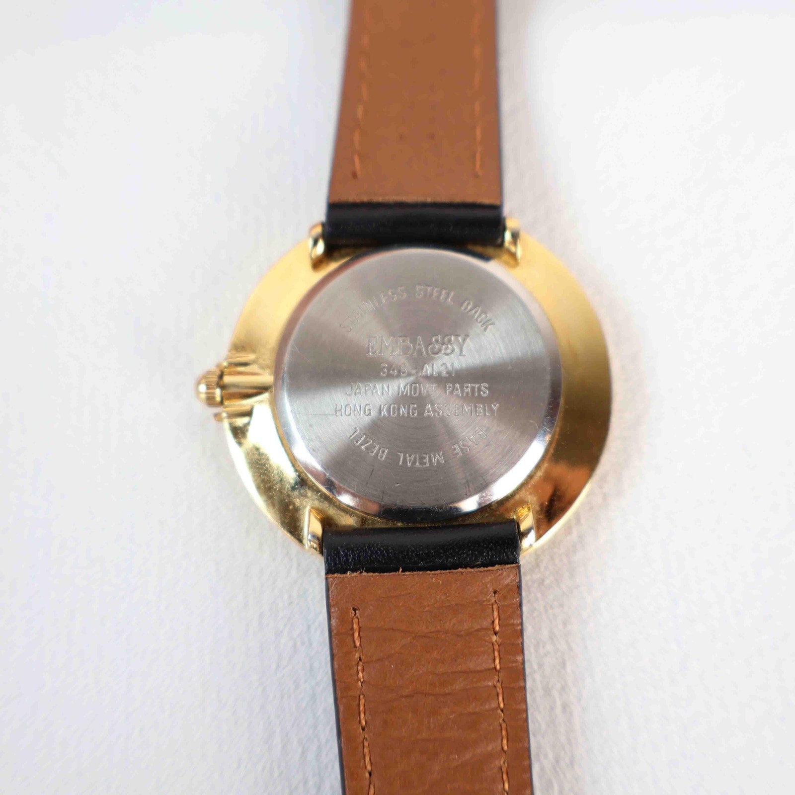 Vintage Embassy Watch with a Gold Round Face and Black Leather Strap